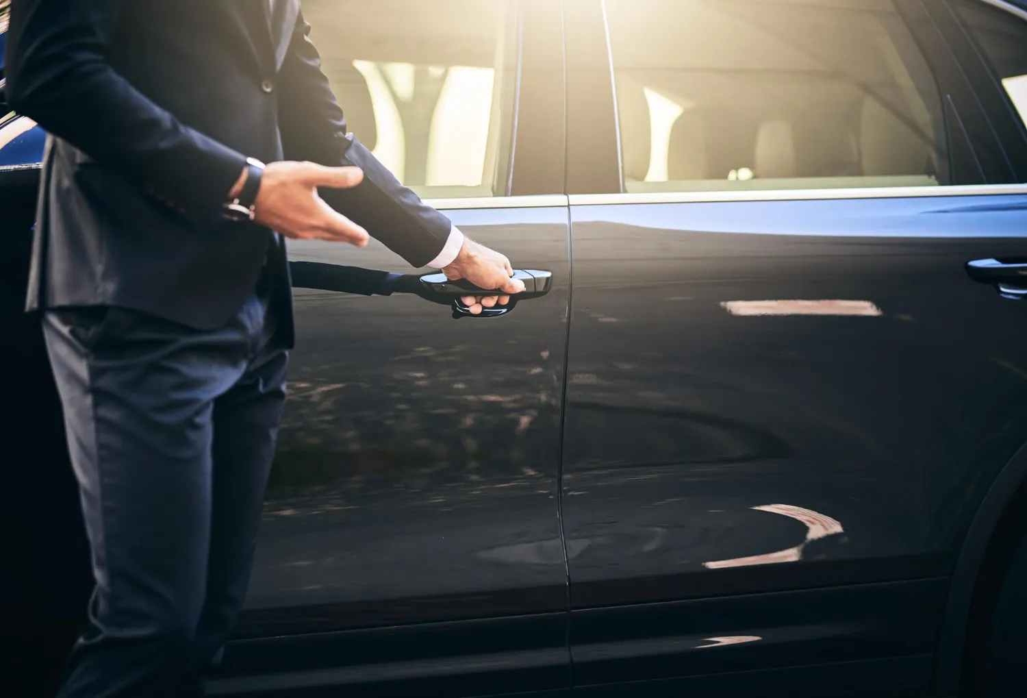 Professional English-speaking chauffeur opening vehicle door, Mexico City